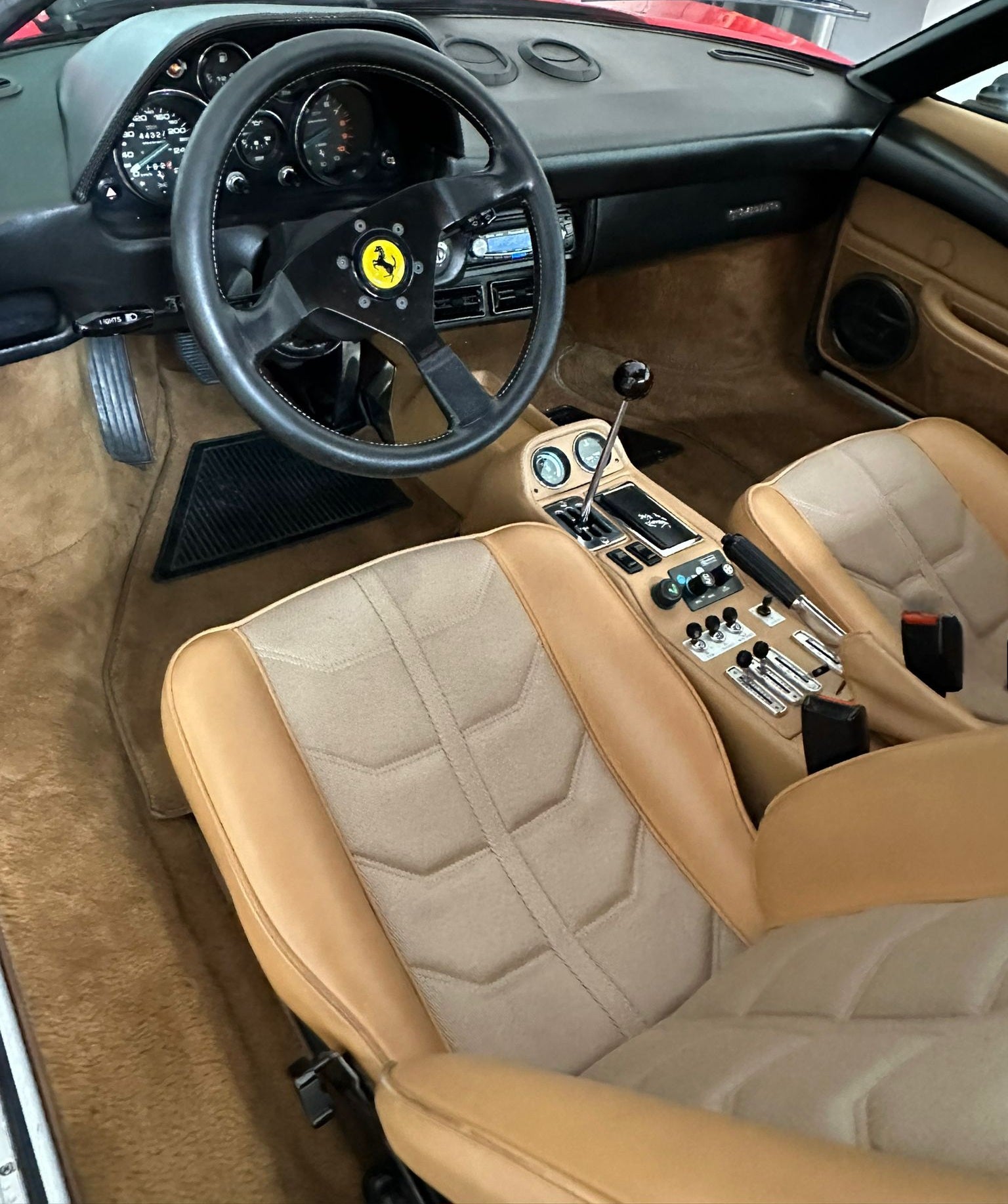 Interior of the 1983 Ferrari 208 GTB – Classic Ferrari cockpit with vintage sports car details. Beige leather.
