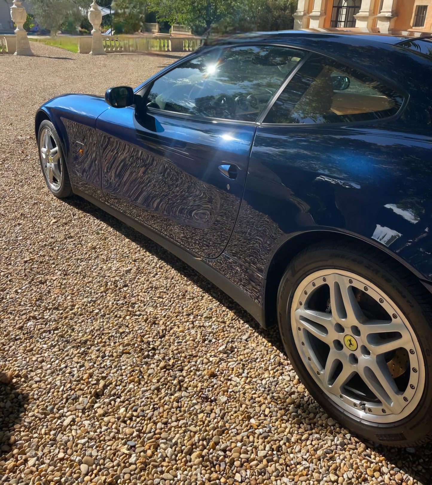 Left side view of the 2005 Ferrari 612 Scaglietti – Sleek Blue Pozzi exterior with Pininfarina styling.